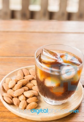 Glass Of Black Iced Coffee With Almond Grain Stock Photo