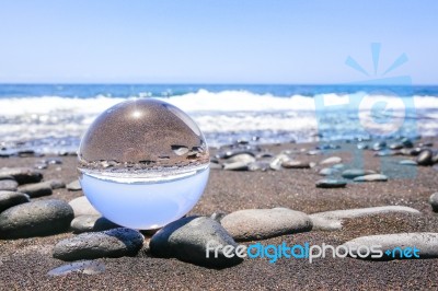 Glass Sphere On Stones At Beach In Madeira Stock Photo