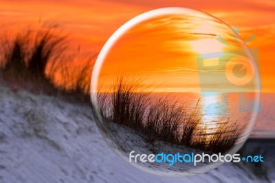 Glass Sphere Reflecting Orange Sunset Stock Photo