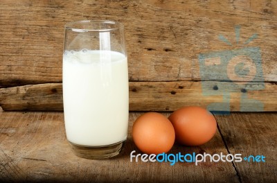 Glass With Milk And Egg On The Wooden Background Stock Photo