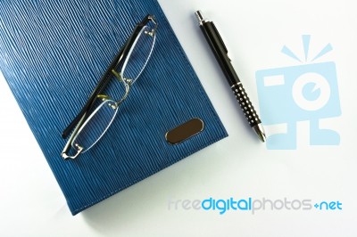 Glasses on Notebook With Pen Stock Photo