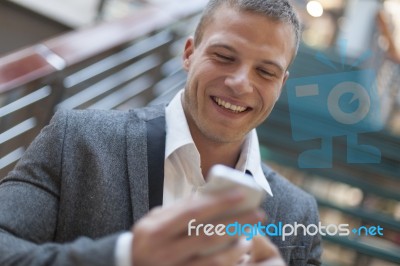 Good News! Men Reading Sms On Smartphone In Business Building Stock Photo