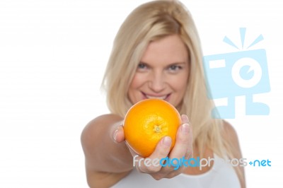 Gorgeous Woman With An Orange In Her Outstretch Arm Stock Photo