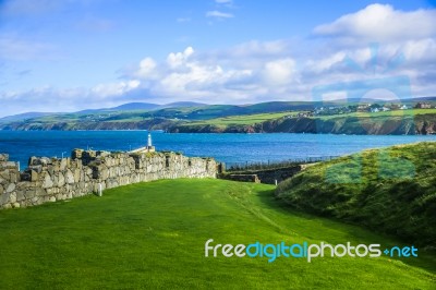 Great Wall Of Peel Castle Constructed By Vikings At Peel Hill Covered With Green Grass And Beautiful Coastline Of Isle Of Man In Background Stock Photo