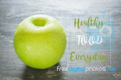 Green Apple On The Table With Healthy Quote Stock Image