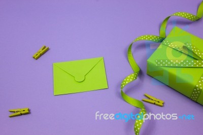 Green Gift With Green Envelope On Lilac Background Stock Photo