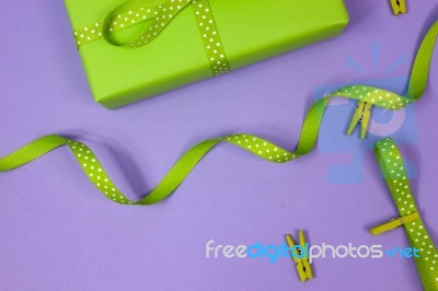 Green Gift With Polka Dot Ribbon On Lilac Background Stock Photo