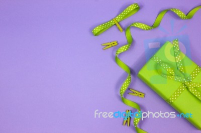 Green Gift With Polka Dot Ribbon On Lilac Background Stock Photo