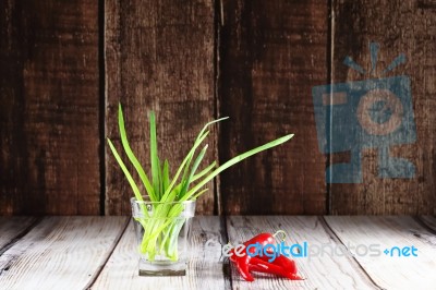 Green Onions And Red Hot Chili Peppers In Glass Of Water Stock Photo