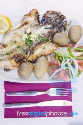 Grilled Fish With Tomato Salad And Potatoes Stock Photo
