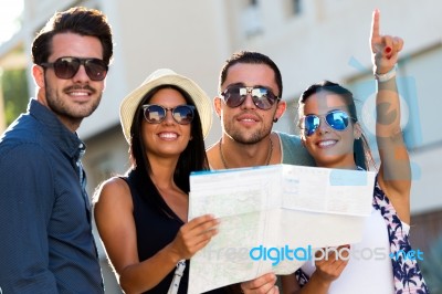 Group Of Friends Use Their Map In The Street Stock Photo