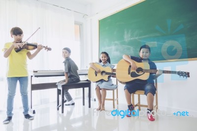 Group Of Happy Asian Kids Or Students Playing Musical Instruments In School Stock Photo