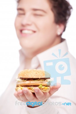 Hamburger In Hand Of A Chubby Man Stock Photo