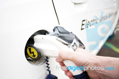 Hand Holding Electric Car Charging Stock Photo