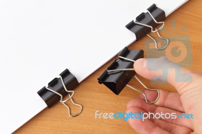 Hand Holding Paper Clip, Paper And Clips On The Table Stock Photo