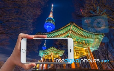 Hand Holding Smart Phone Take A Photo At Seoul Tower At Night Stock Photo
