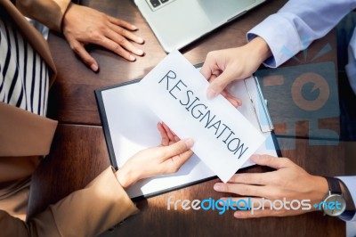 Hand Of A Businessman Hands Over A Resignation Letter On A Woode… Stock Photo