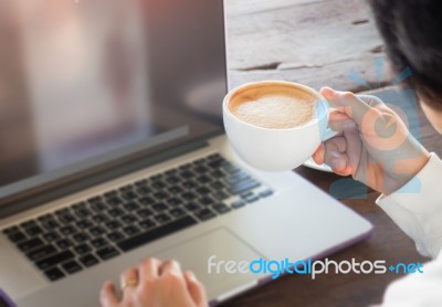 Hand On Cup Of Coffee At Work Table Stock Photo