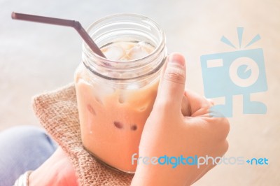 Hand On Glass Of Iced Milk Coffee With Vintage Filter Effect Stock Photo