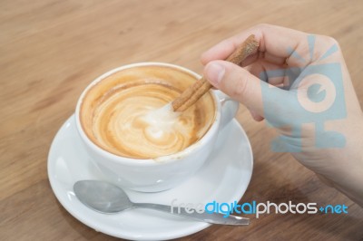 Hand On Hot Cup Of Coffee Latte Stock Photo