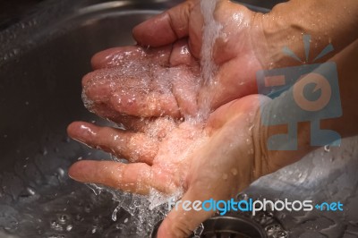 Hands Being Washed Under Stream Of Water Stock Photo