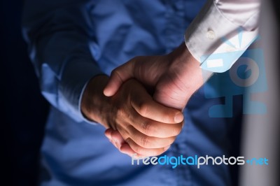 Handshake Handshaking In Dark With Low Light Stock Photo