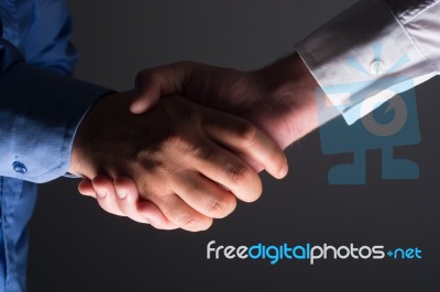 Handshake Handshaking In Dark With Low Light Stock Photo