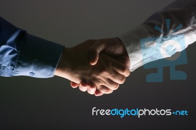 Handshake Handshaking In Dark With Low Light Stock Photo