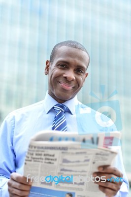 Handsome Male Executive Reading A Newspaper Stock Photo