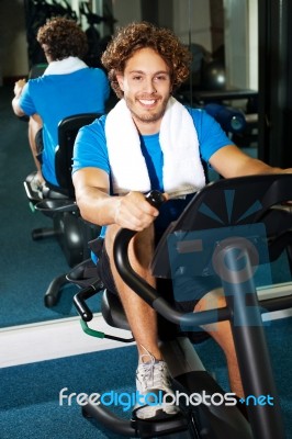 Handsome Man At The Gym Doing Static Cycling Stock Photo