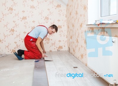 Handyman Laying Down Laminate Flooring Boards Stock Photo