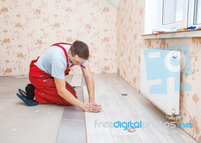 Handyman Laying Down Laminate Flooring Boards Stock Photo