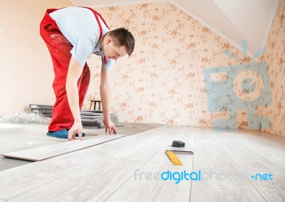 Handyman Laying Down Laminate Flooring Boards Stock Photo