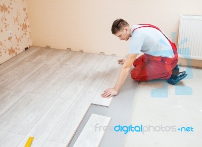 Handyman Laying Down Laminate Flooring Boards Stock Photo