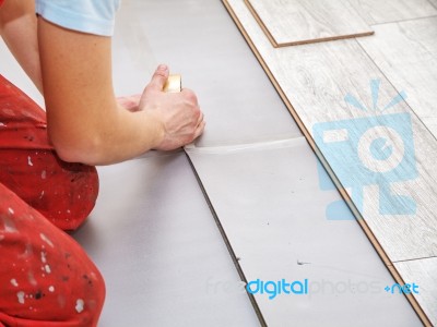 Handyman's Hands Laying Down Laminate Flooring Boards Stock Photo