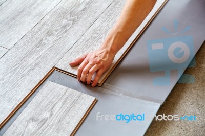 Handyman's Hands Laying Down Laminate Flooring Boards Stock Photo
