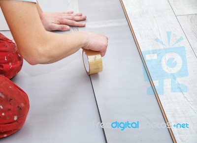 Handyman's Hands Laying Down Laminate Flooring Boards Stock Photo