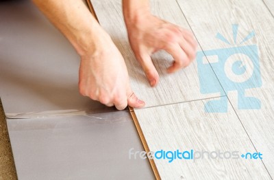 Handyman's Hands Laying Down Laminate Flooring Boards Stock Photo