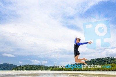 Happy Asian Teen Girl Jumping Fun On The Beach Stock Photo