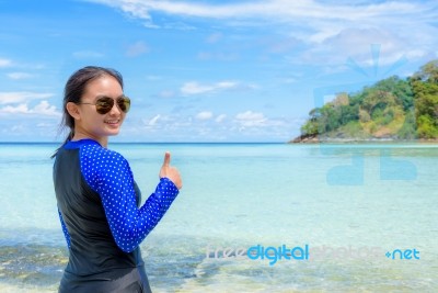 Happy Asian Woman Turning To Smile With Thumb Up At The Beach Stock Photo