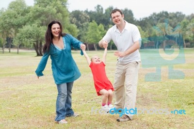 Happy Couple Playing With Their Daughter Stock Photo