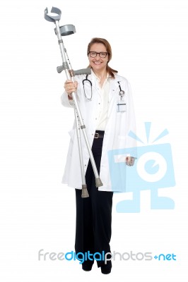 Happy Doctor Posing With Crutches In Hand Stock Photo