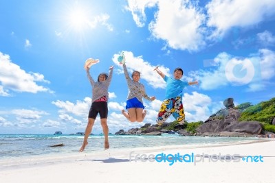 Happy Family Jumping On Beach In Thailand Stock Photo