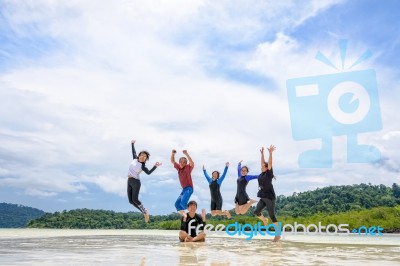 Happy Family Jumping Together On The Beach, Thailand Stock Photo