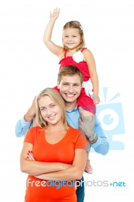Happy Family Of Three Members Standing In Embrace Stock Photo