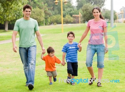 Happy Family Walking In The Park Stock Photo