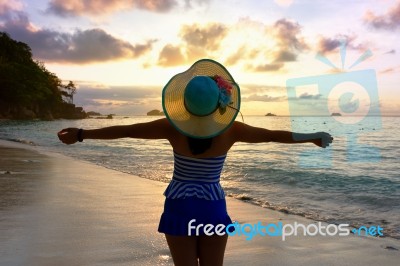 Happy Girl On The Beach At Sunrise Stock Photo