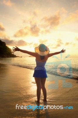 Happy Girl On The Beach At Sunrise Stock Photo