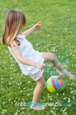 Happy Little Girl Playing Ball In The Park Stock Photo