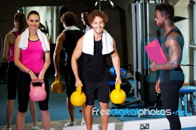 Happy Man And Woman Lifting Kettlebell Stock Photo